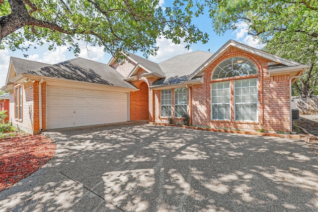 view of front of property with a garage and central AC