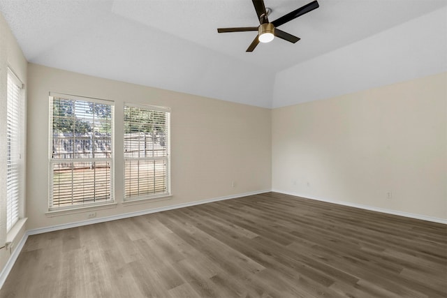 empty room with a textured ceiling, vaulted ceiling, hardwood / wood-style floors, and ceiling fan