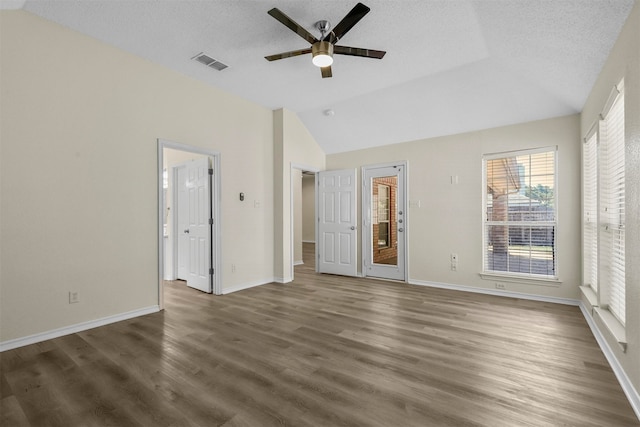 unfurnished bedroom featuring a textured ceiling, lofted ceiling, dark wood-type flooring, and ceiling fan