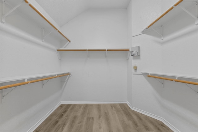 walk in closet featuring wood-type flooring and lofted ceiling