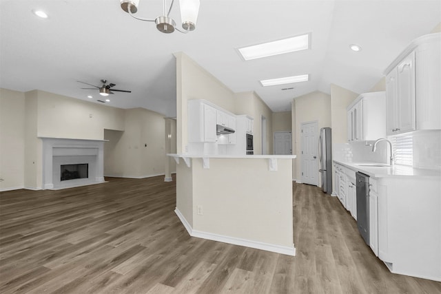 kitchen with ceiling fan with notable chandelier, white cabinetry, sink, and hardwood / wood-style flooring