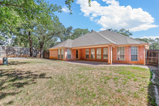 rear view of property with a yard and a patio