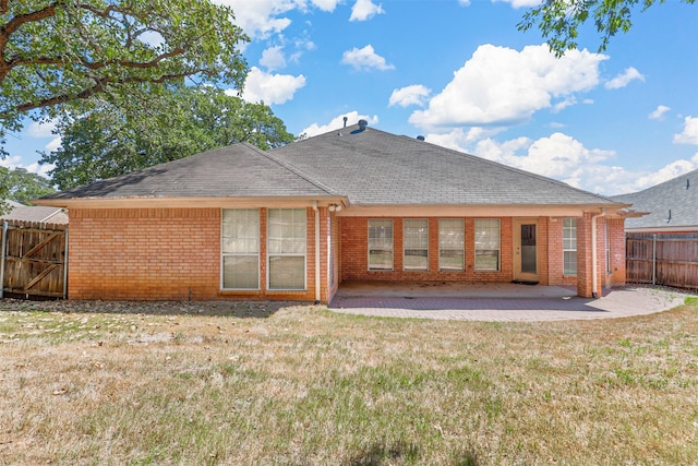 rear view of house featuring a yard and a patio