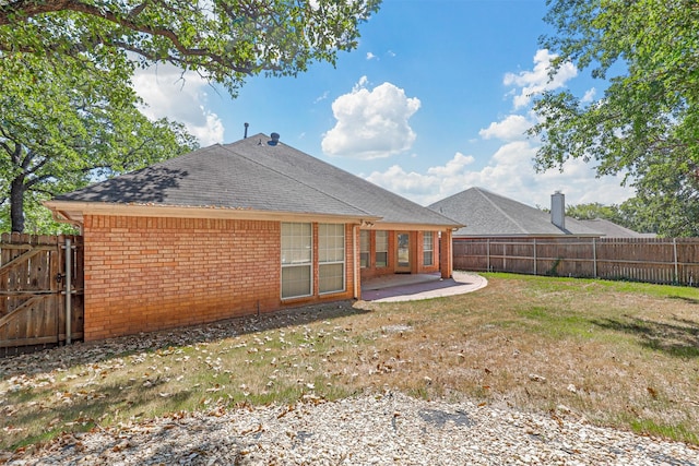 rear view of property featuring a patio and a lawn