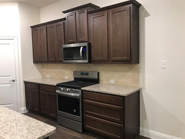 4111 Beamer Dr, Forney, TX 75126 - kitchen featuring tasteful backsplash, dark brown cabinetry, baseboards, and appliances with stainless steel finishes