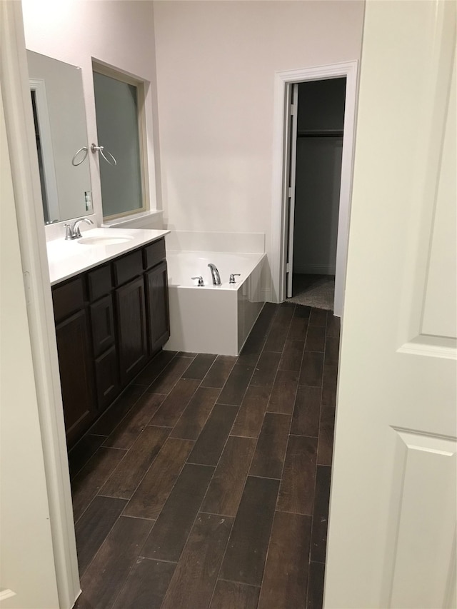 bathroom with vanity, hardwood / wood-style floors, and a bathing tub