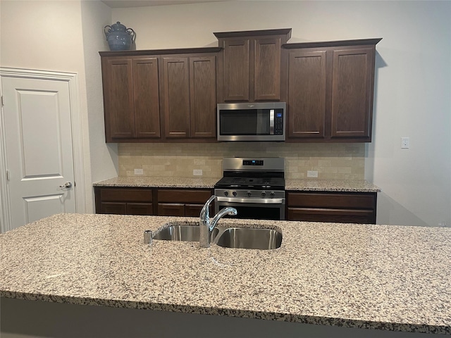 4111 Beamer Dr, Forney, TX 75126 - kitchen featuring a sink, dark brown cabinets, appliances with stainless steel finishes, and light stone countertops
