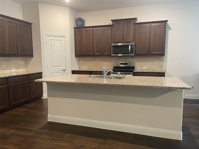 4111 Beamer Dr, Forney, TX 75126 - kitchen featuring dark brown cabinetry, appliances with stainless steel finishes, a sink, a center island with sink, and dark wood-style floors