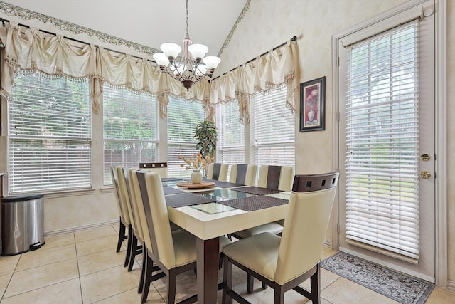 tiled dining room with lofted ceiling and an inviting chandelier