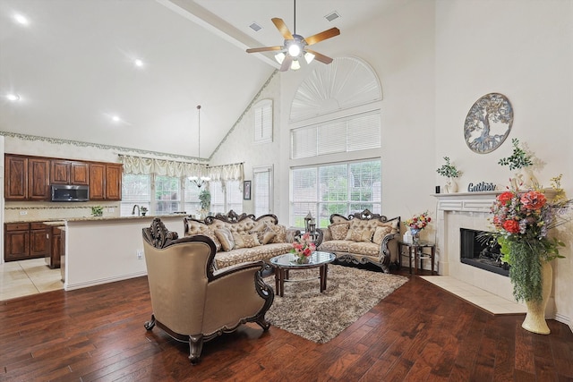 living room featuring a fireplace, dark hardwood / wood-style flooring, ceiling fan, and high vaulted ceiling