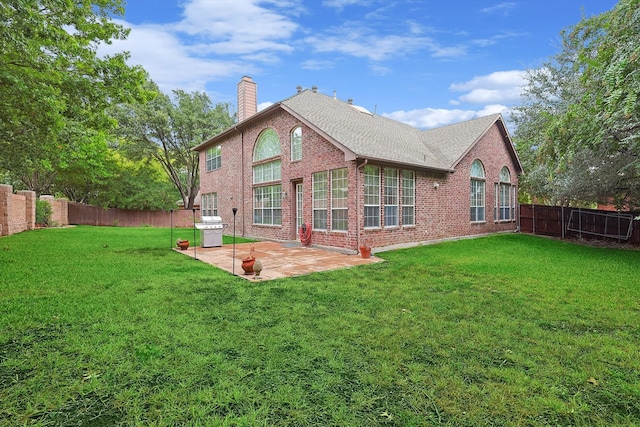 rear view of property with a yard and a patio area