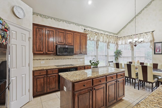 kitchen featuring black electric cooktop, a center island, a notable chandelier, light tile patterned floors, and decorative light fixtures