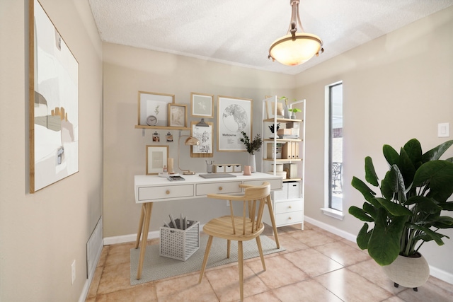 office space featuring a textured ceiling and light tile patterned floors