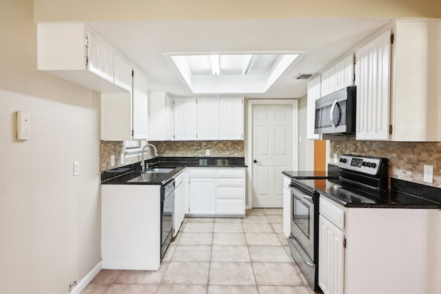 kitchen featuring light tile patterned flooring, sink, white cabinets, a raised ceiling, and appliances with stainless steel finishes