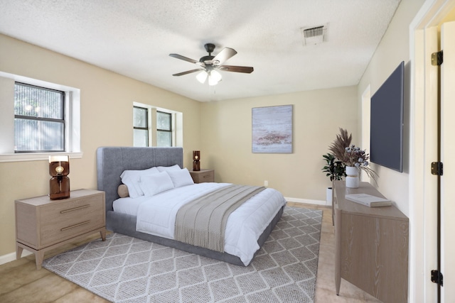 bedroom with a textured ceiling, ceiling fan, and light colored carpet