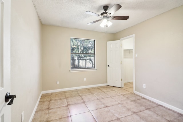 tiled spare room featuring ceiling fan and a textured ceiling