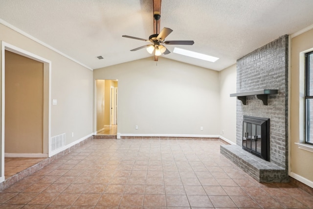 unfurnished living room with a healthy amount of sunlight, ceiling fan, lofted ceiling with skylight, and a fireplace