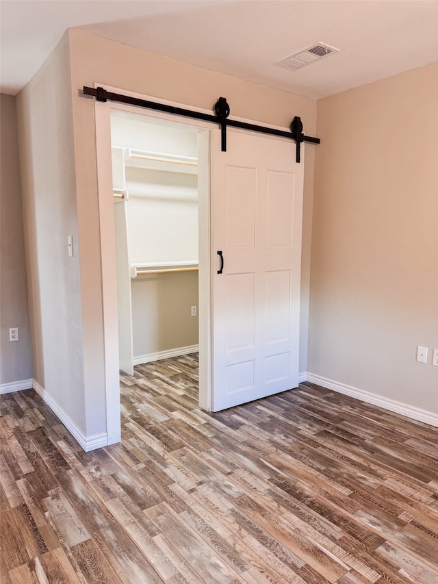 interior space with wood-type flooring and a barn door