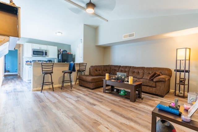 living room with light hardwood / wood-style floors, lofted ceiling, and ceiling fan