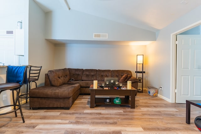 living room with light wood-type flooring and vaulted ceiling