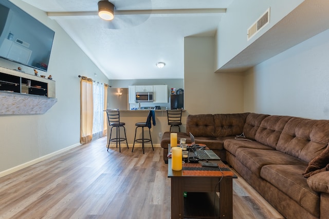 living room with vaulted ceiling with beams, ceiling fan, and hardwood / wood-style flooring