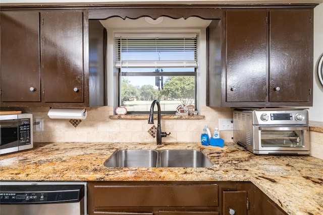 kitchen with decorative backsplash, sink, dark brown cabinetry, and stainless steel appliances