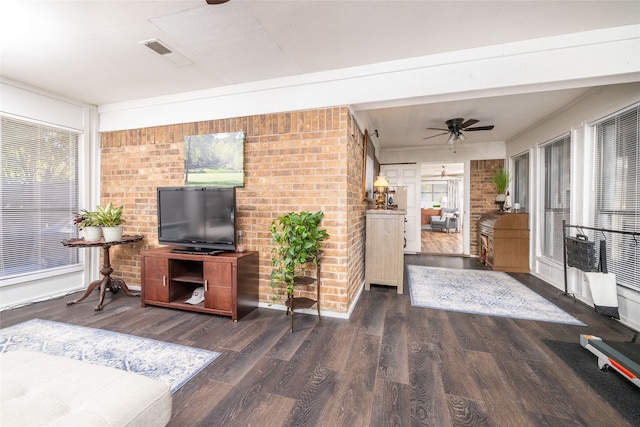 living room featuring dark wood-type flooring, ceiling fan, and a healthy amount of sunlight