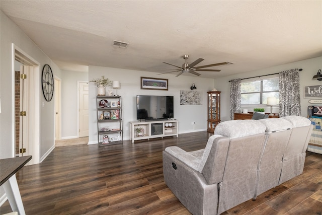 living room featuring dark hardwood / wood-style flooring, a textured ceiling, and ceiling fan