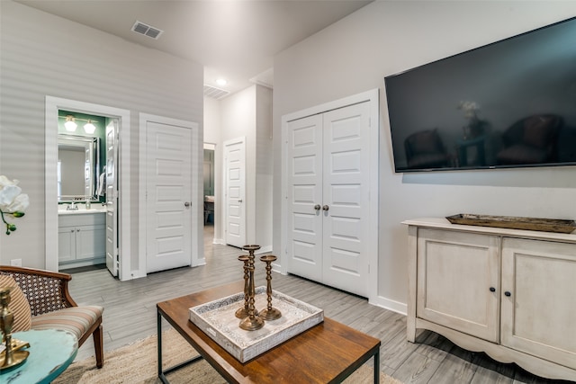 living room with light hardwood / wood-style flooring and sink