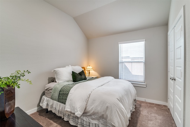 bedroom featuring lofted ceiling and dark carpet