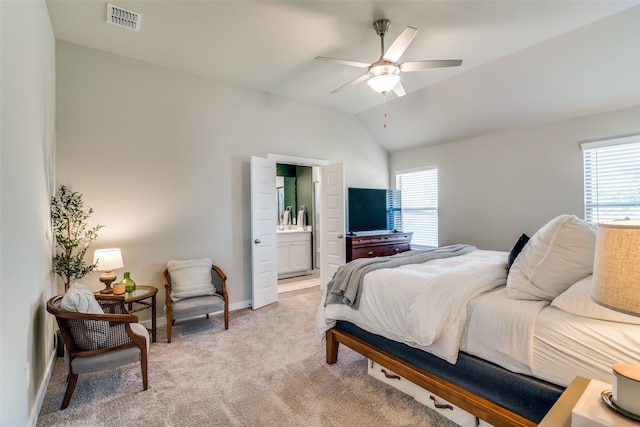 bedroom featuring multiple windows, connected bathroom, lofted ceiling, and ceiling fan