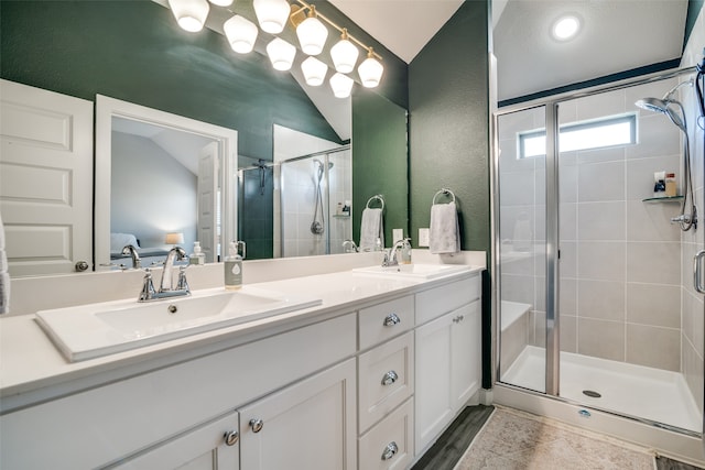 bathroom featuring wood-type flooring, vanity, lofted ceiling, and a shower with shower door