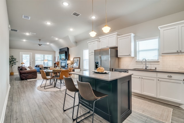 kitchen with hanging light fixtures, ceiling fan, stainless steel fridge with ice dispenser, and white cabinets