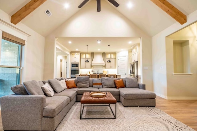 living room with ceiling fan, beam ceiling, high vaulted ceiling, and light wood-type flooring