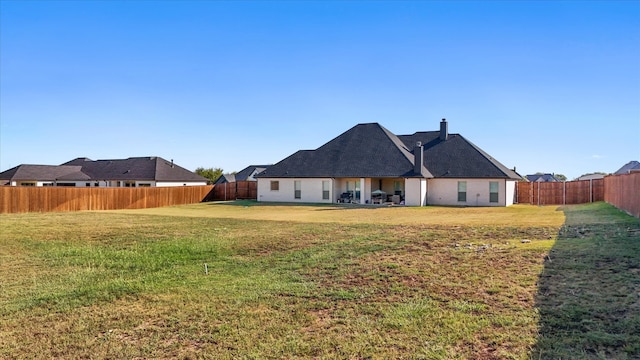 rear view of property featuring a yard