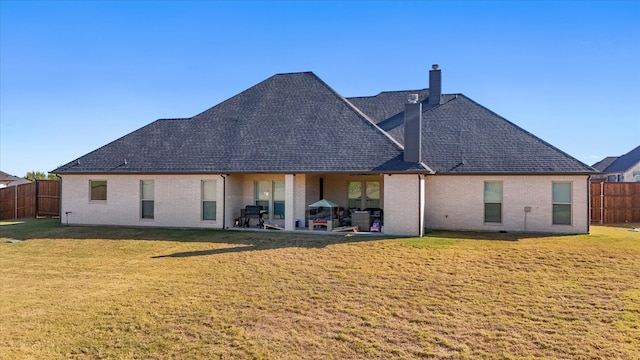 back of house with a yard and a patio