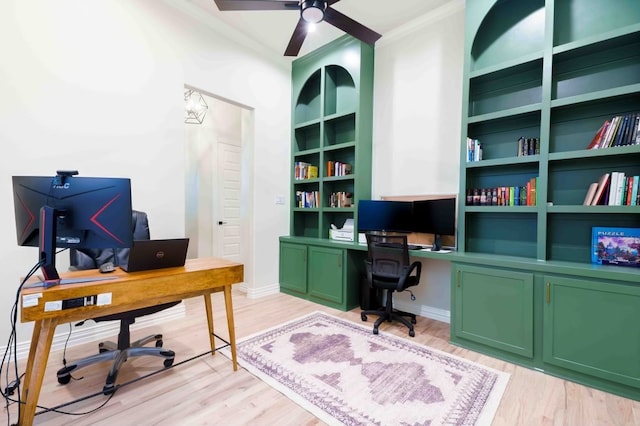 office area featuring crown molding, ceiling fan, built in shelves, and light hardwood / wood-style flooring