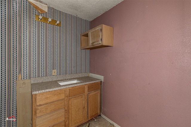 interior space featuring a textured ceiling and vanity