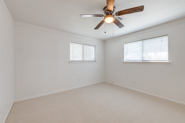 spare room with ornamental molding, ceiling fan, and light colored carpet