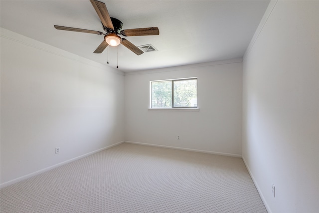 carpeted empty room with ceiling fan and crown molding