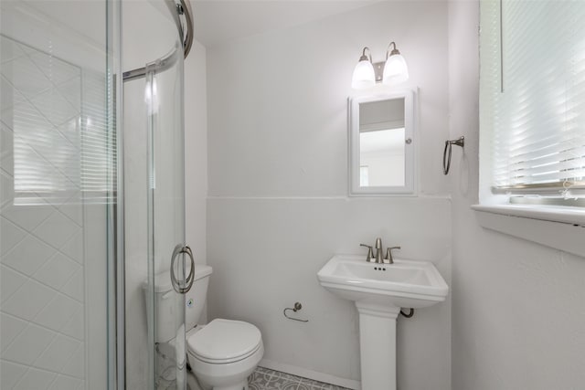 bathroom featuring toilet and a shower with shower door