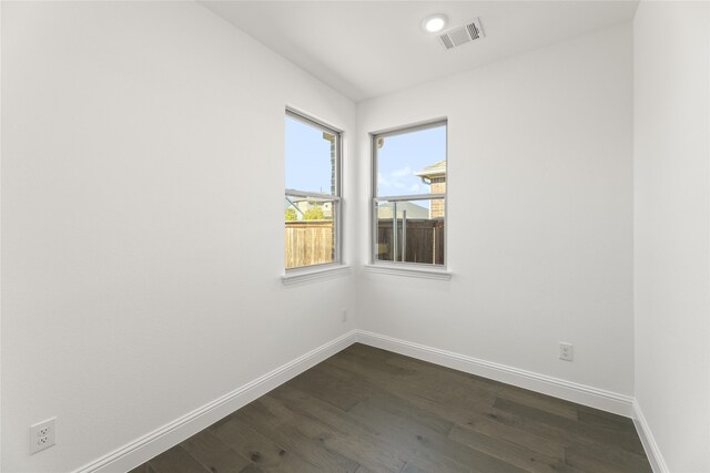 spare room featuring dark wood finished floors, recessed lighting, baseboards, and visible vents