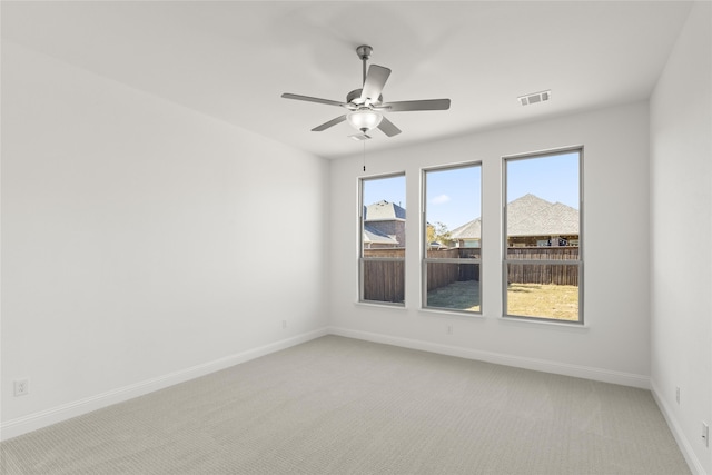 spare room featuring ceiling fan and light carpet