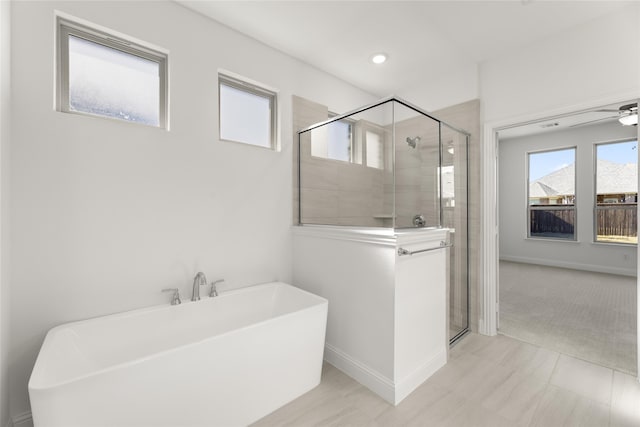 full bath featuring baseboards, a freestanding bath, recessed lighting, a stall shower, and a ceiling fan