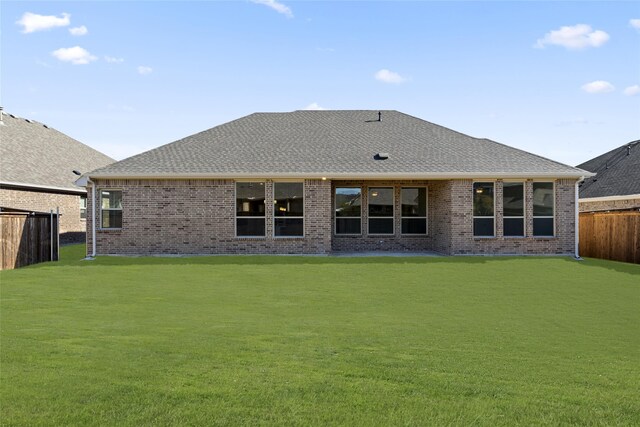 rear view of property with a lawn