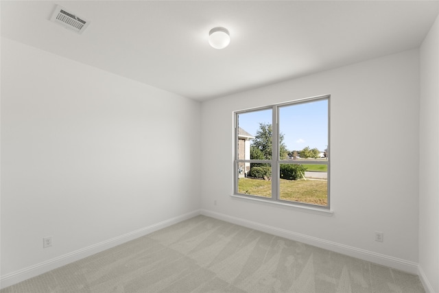 spare room featuring visible vents, baseboards, and light colored carpet