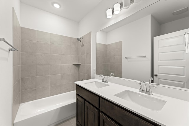 bathroom with double vanity, tile patterned flooring, washtub / shower combination, and a sink