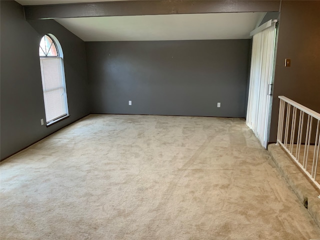 carpeted empty room featuring lofted ceiling