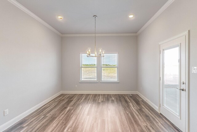 unfurnished dining area with ornamental molding, dark hardwood / wood-style floors, and a notable chandelier