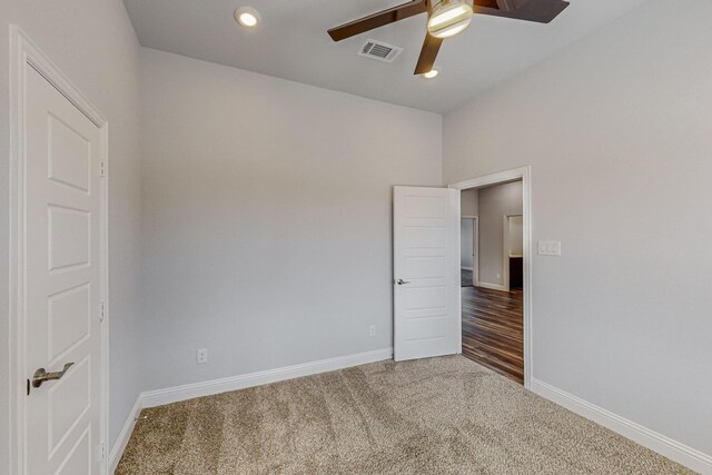 carpeted spare room featuring ceiling fan